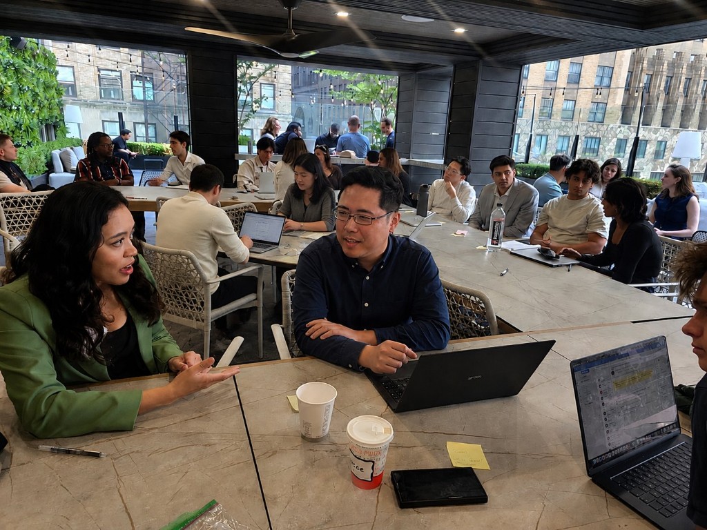 Alisha Outridge leading an AI Founder Playbook masterclass at NY Tech Week — founders at tables with laptops and sticky notes